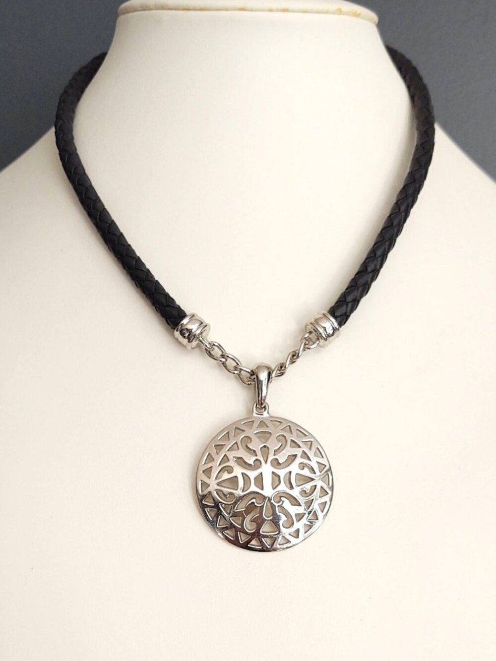 Silver medallion necklace on black leather cording